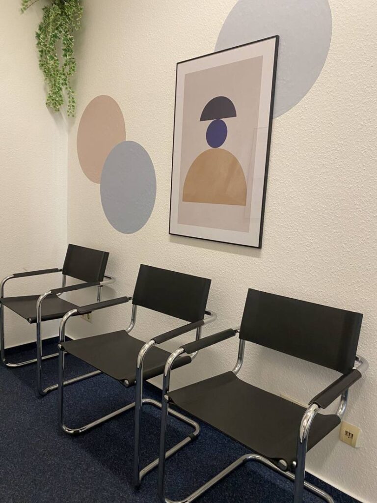 Wartebereich mit Freischwinger-Stühlen und Kunstdruck im Flur der Praxis Mainzer Straße